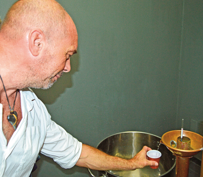 Philippe Bruot récupère l’alcool qui sort tout juste de l’alambic. Un liquide à 90 degrés, qui sera ensuite refroidi.