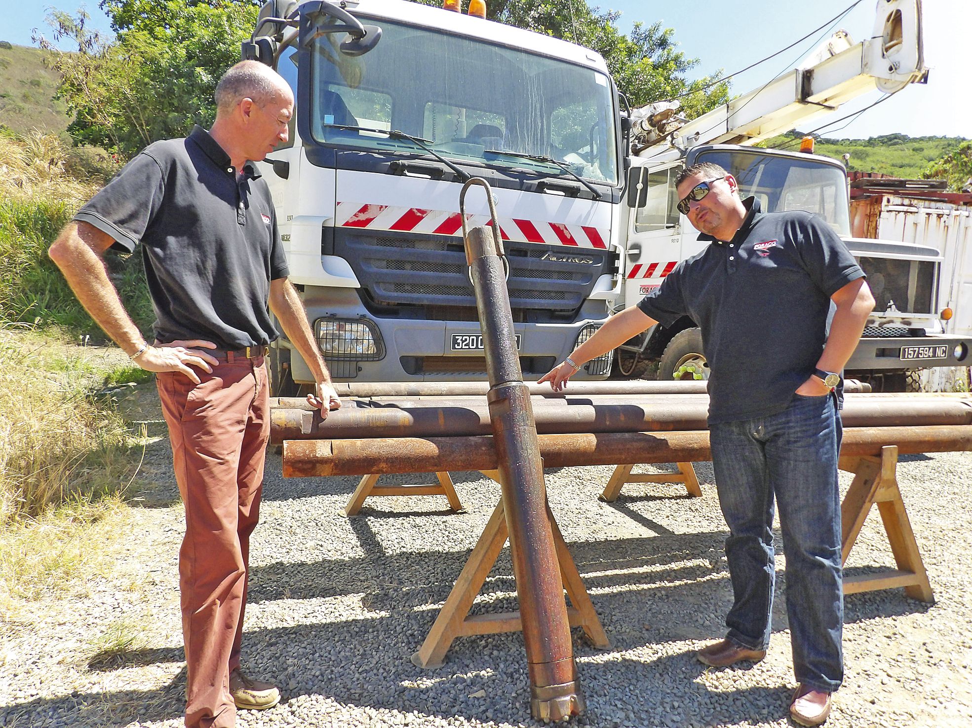 Les deux responsables de l’entreprise montrent le marteau-piqueur qui sera utilisé pour casser la roche.    