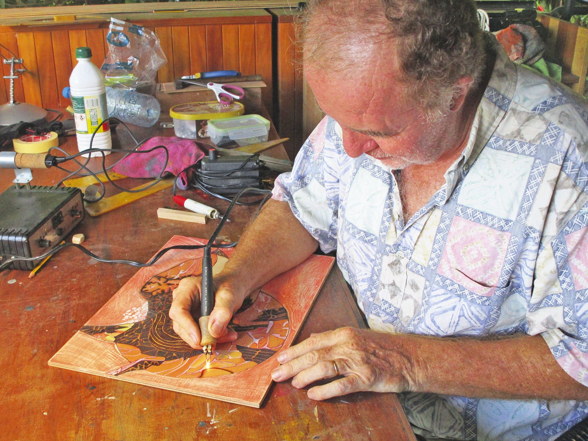 La pyrogravure constitue la première étape de Bruno Curet, (ici dans son atelier à Tahiti) qui y revient cependant plusieurs fois au cours de son processus de création.