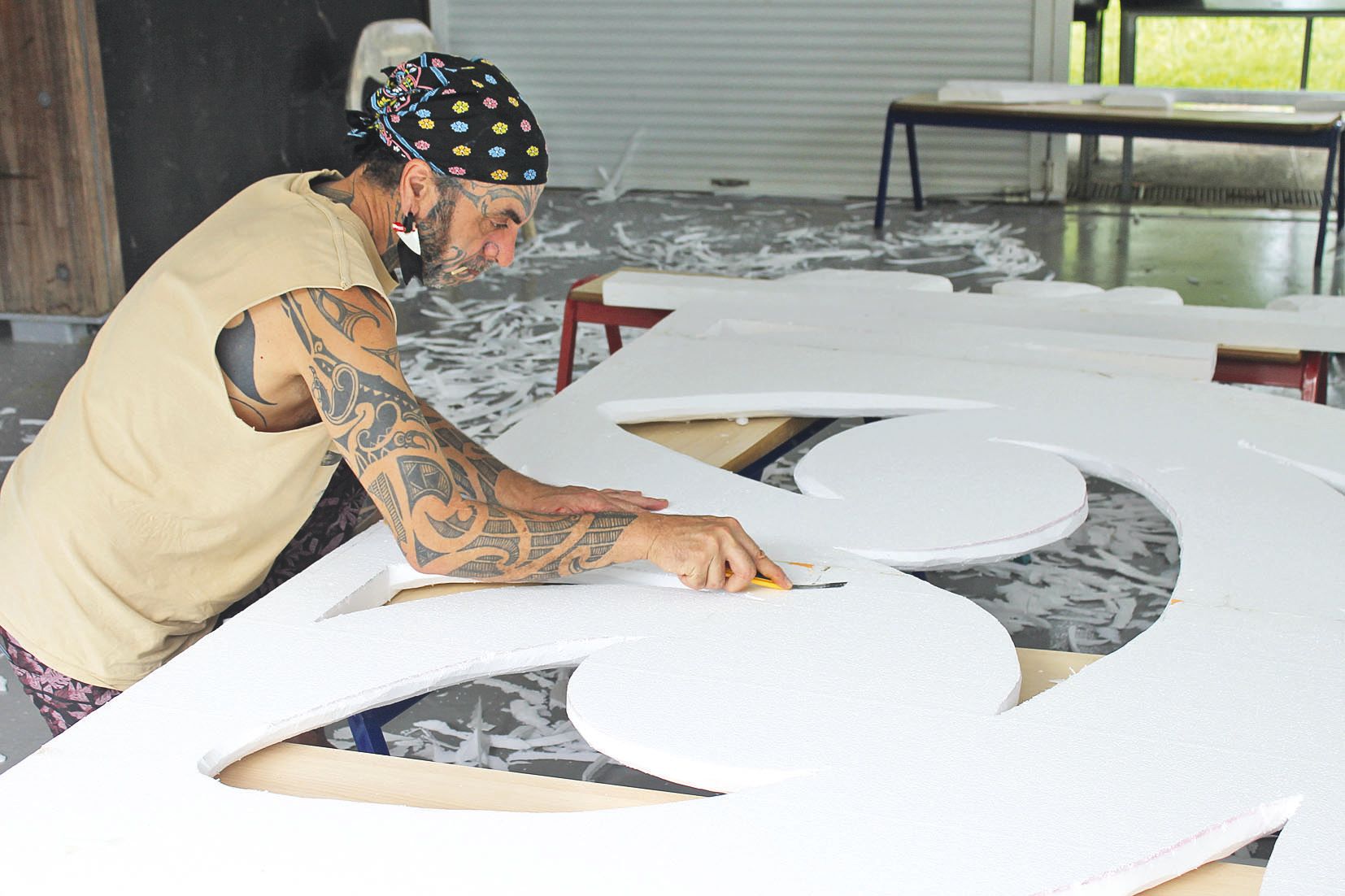 Armé d’un simple cutter, George Nuku a sculpté les immenses panneaux destinés à emprisonner un véritable crâne de baleine en case Kanaké.  Un travail de titan.