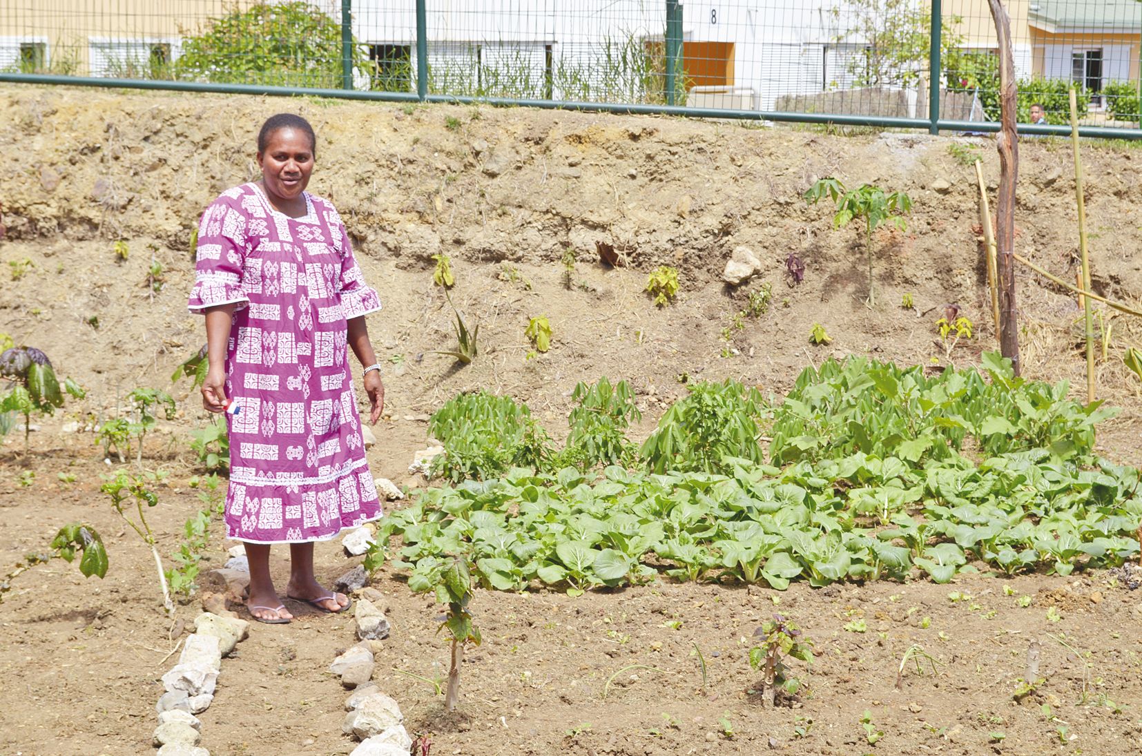 Suzanne pose dans son jardin, fière de ses plantations.  Un plaisir pour celle qui vient en prendre soin tous les jours.
