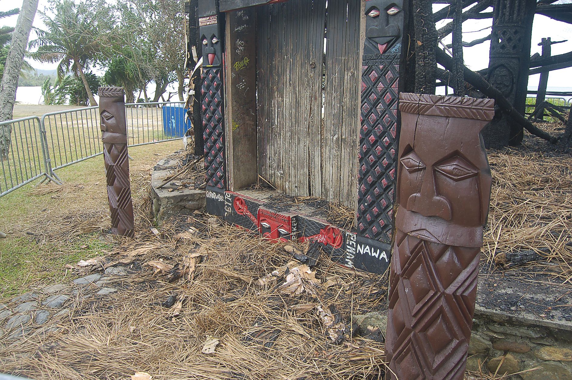 Les chambranles de la case et les deux sculptures  monumentales, situées en avant, ont échappé au brasier.
