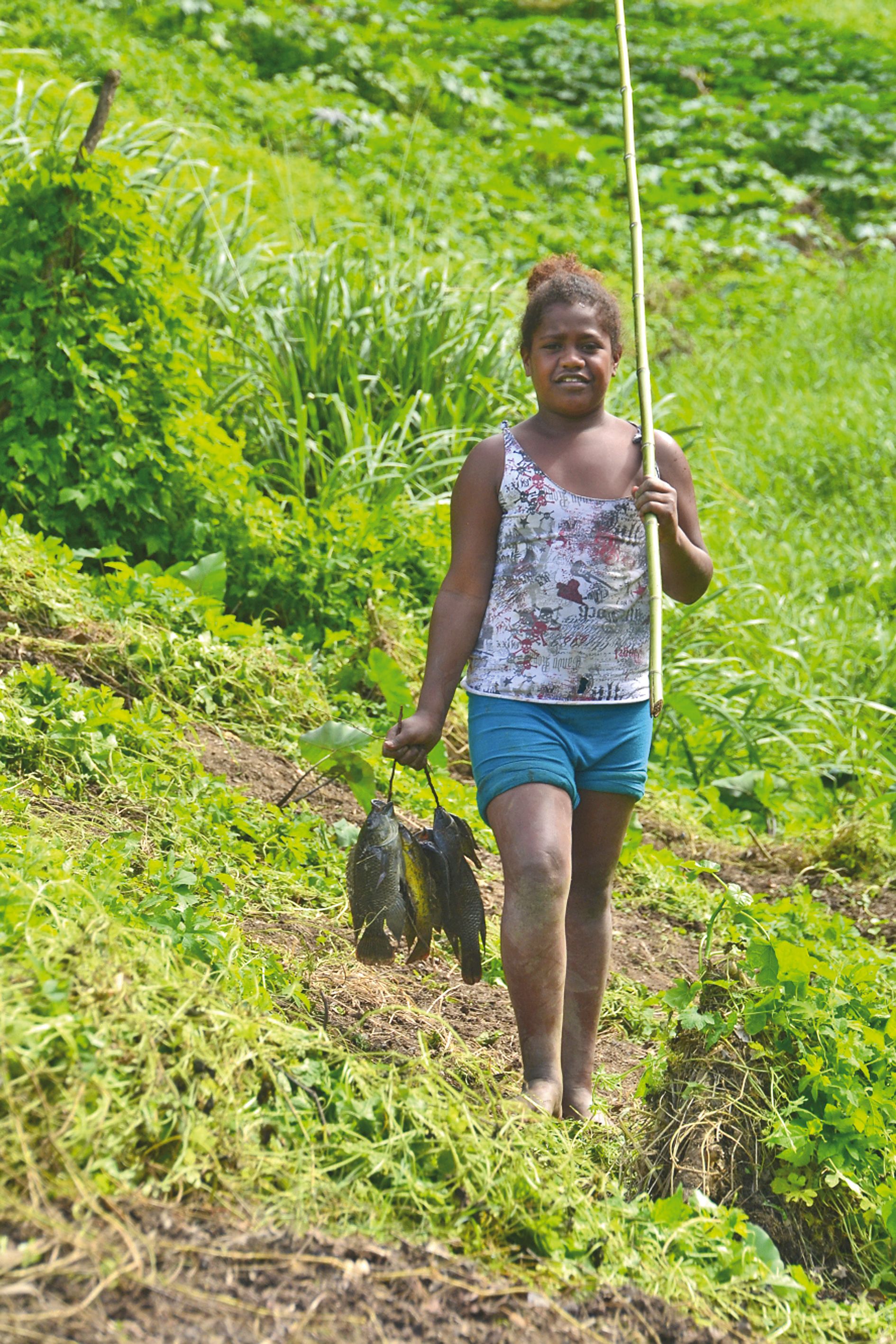 Retour de la pêche pour Noélie, fière d’avoir attrapé une bonne prise avec une canne qu’elle a elle-même fabriquée.
