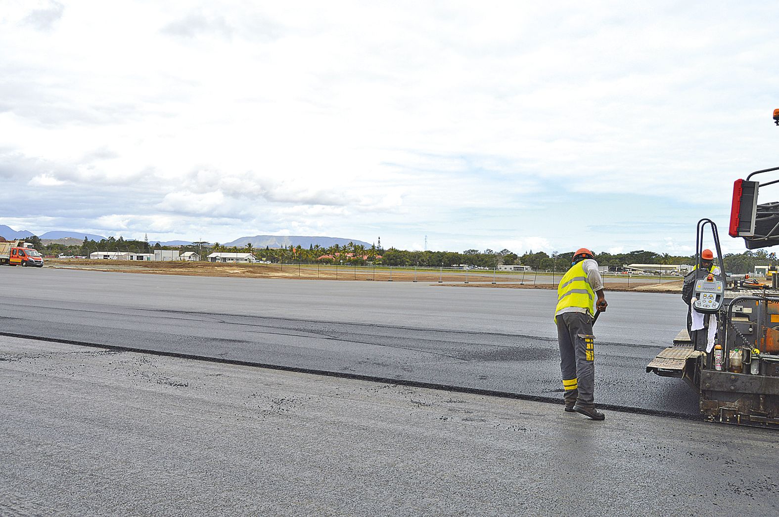 Vue sur la piste et l’aérogare depuis l’aire de stationnement. Une bretelle d’accès fait le lien.