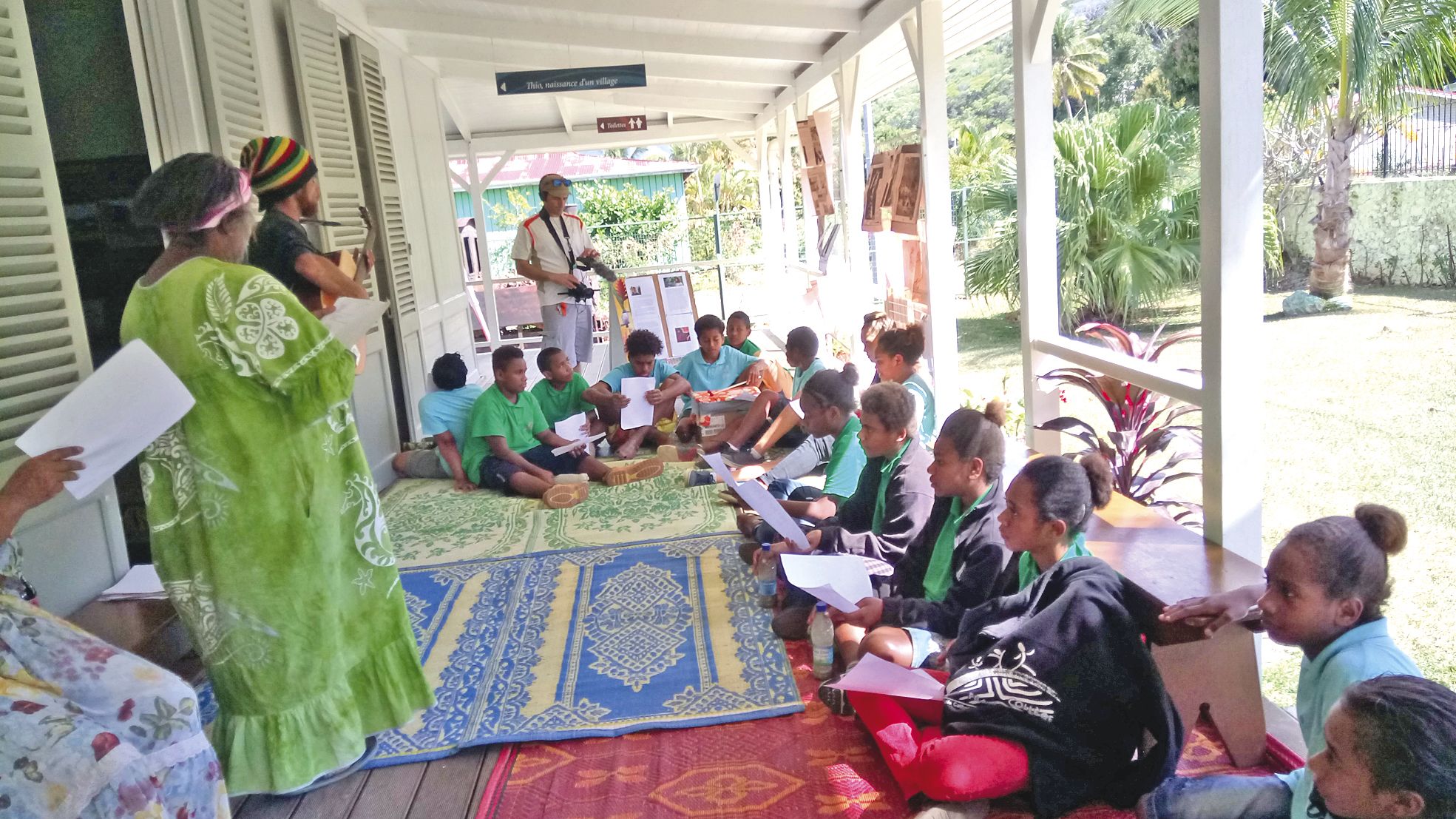 Installé sur des nattes sous le porche du musée, un groupe de collégiens participe à un atelier conte avec Marie Tamai et Alex Gnahou.