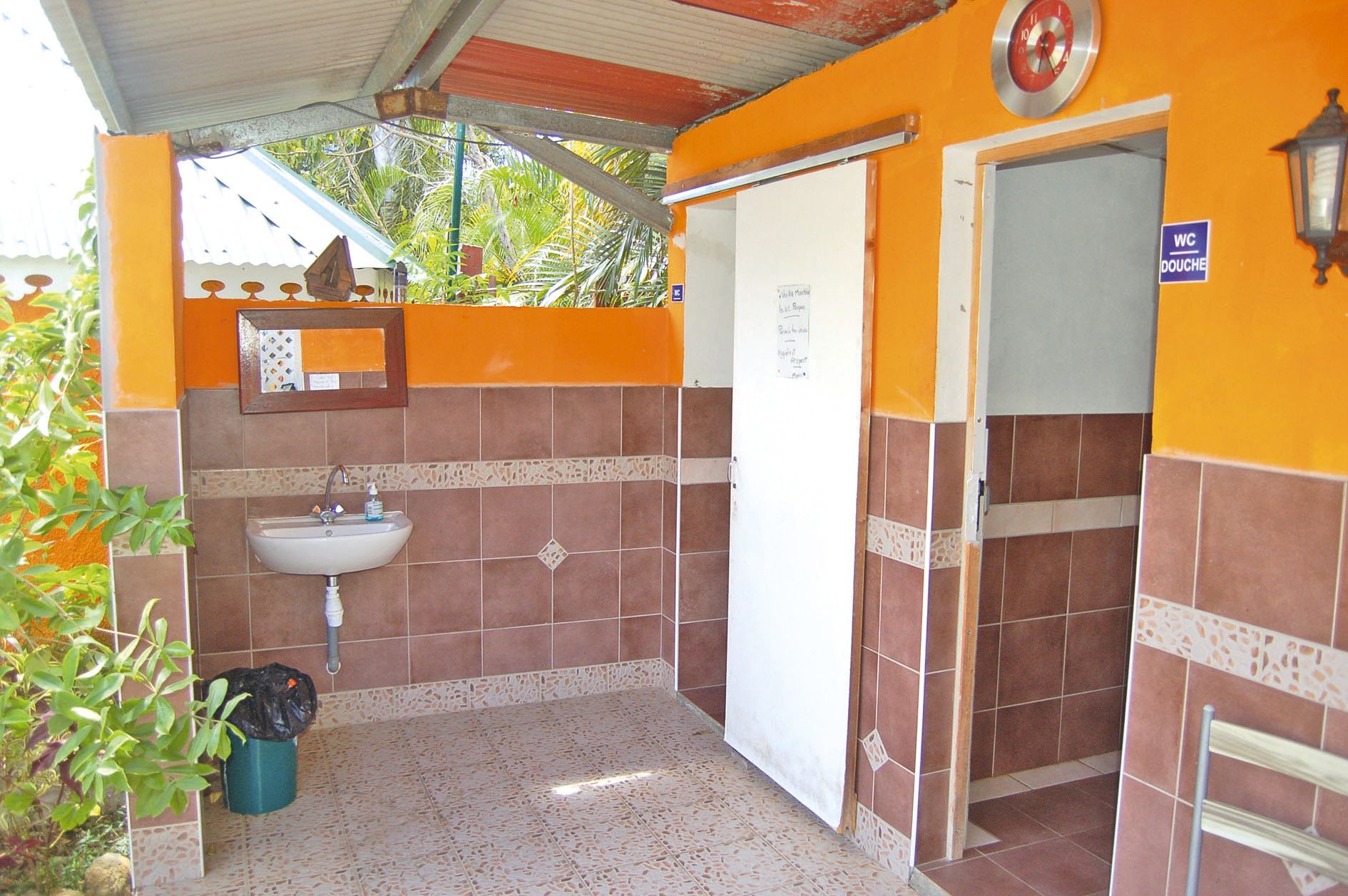 Le bloc sanitaires communs pour les clients de la case et du camping est alimenté en eau chaude et dispose de deux vastes douches à l’italienne.