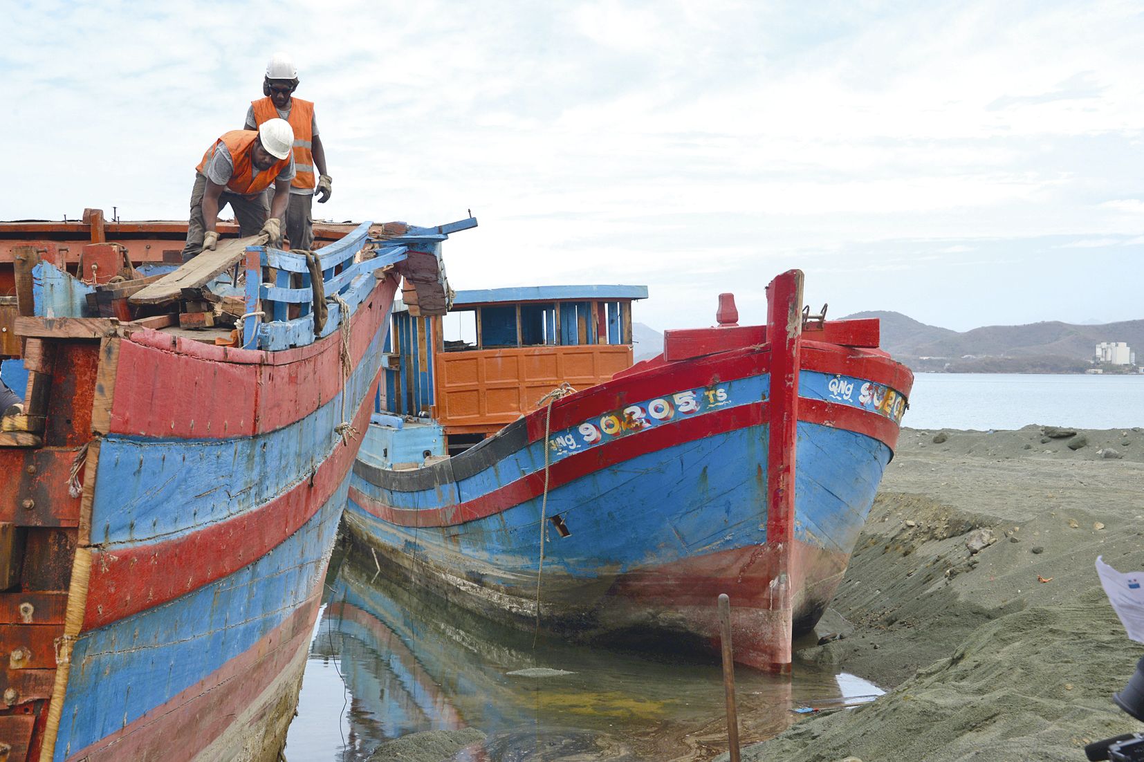Trop lourd pour être sorti hors de l’eau entier, ce blue-boat a dû être coupé en deux pour pouvoir être remorqué. Les ouvriers utilisent ensuite des tronçonneuses pour en venir à bout.