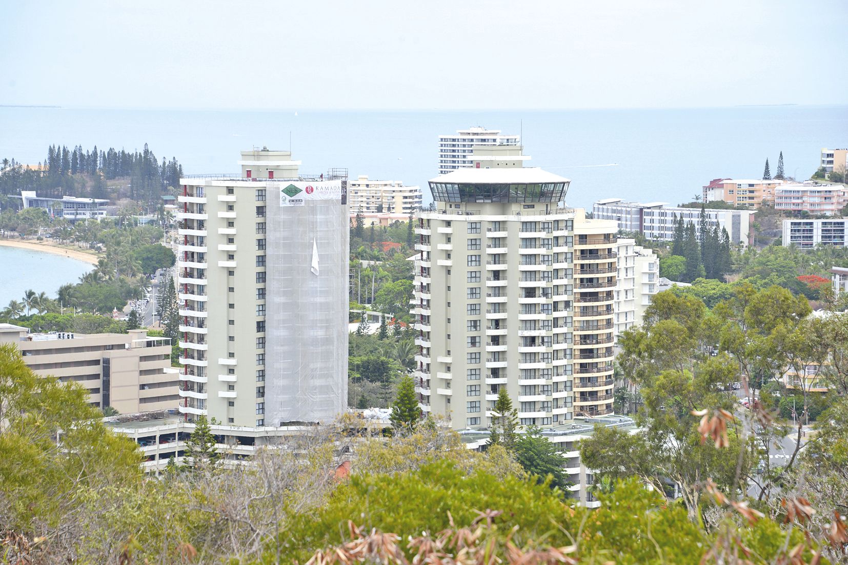 Au centre, l’hôtel Ramada, ses 18 niveaux et ses 55 mètres de haut. A son sommet se trouve le restaurant tournant, une des attractions du lieu. La tour dépasse, à droite, la résidence Isle de France aujourd’hui Moaro, la première tour qui ait été construi