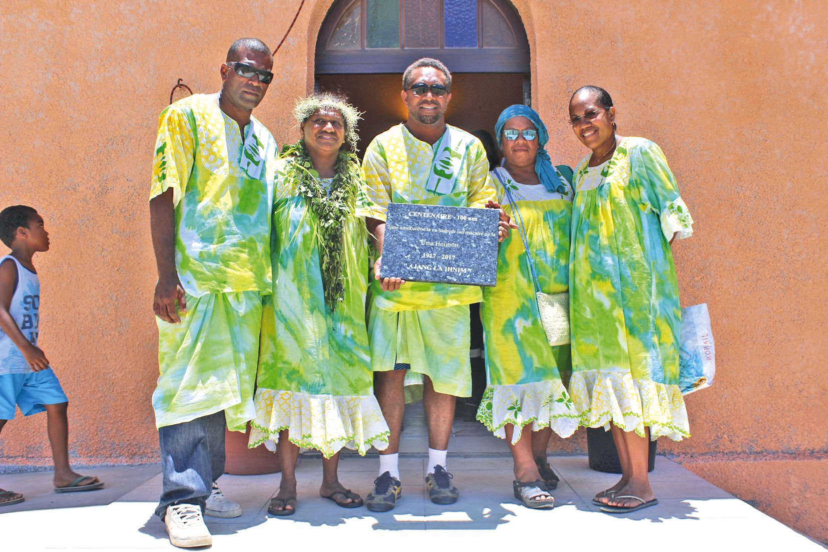 La présidente du comité (2e à droite), la femme du diacre et les membres du comité montrent la plaque du temple.