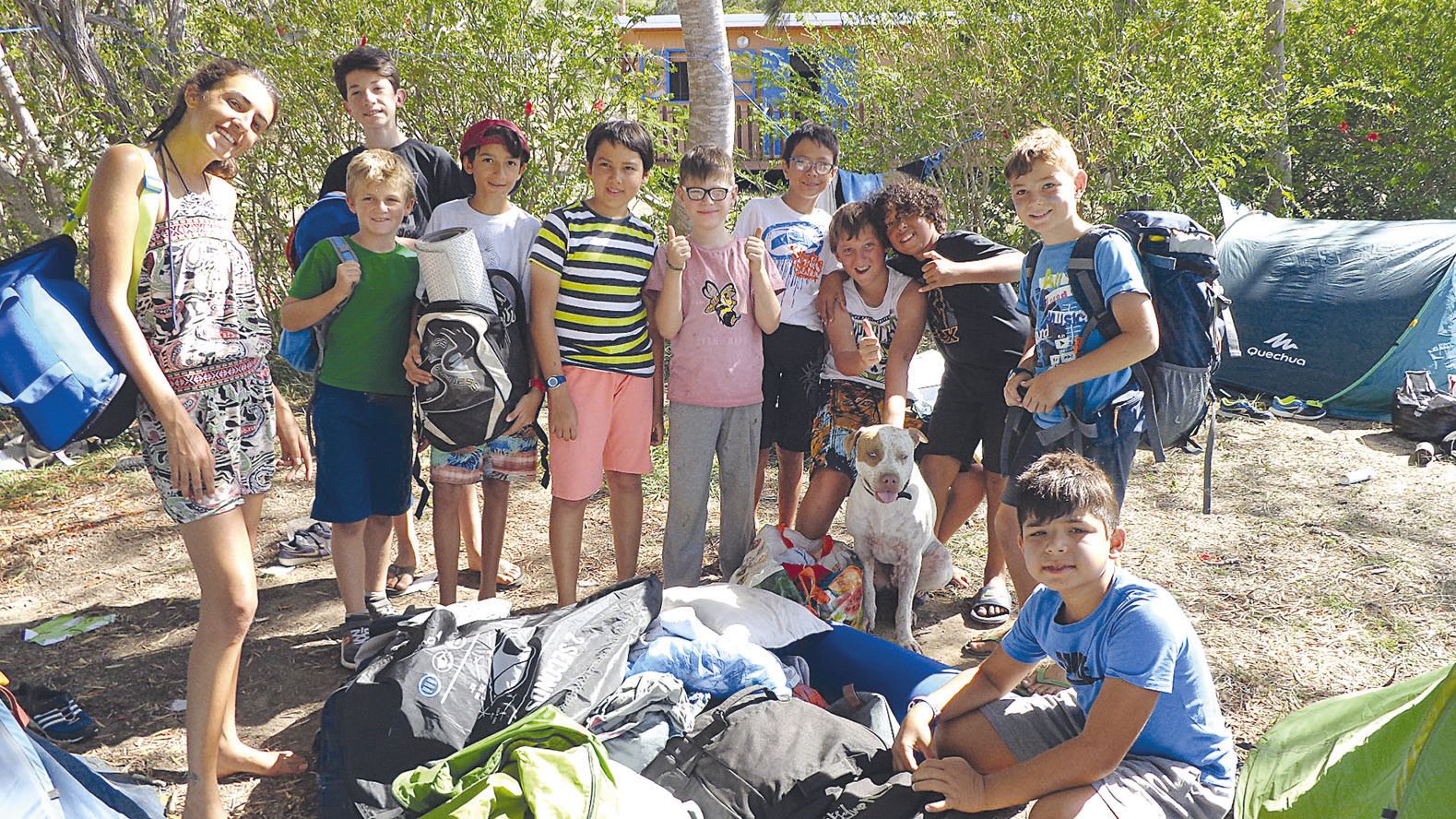 Jeudi à Bouraké, les enfants ont ramassé leurs toiles de tente pour préparer leur  dernière soirée, avec l’aide de Mandhora, l’animatrice, et de Maki, le chien du centre.