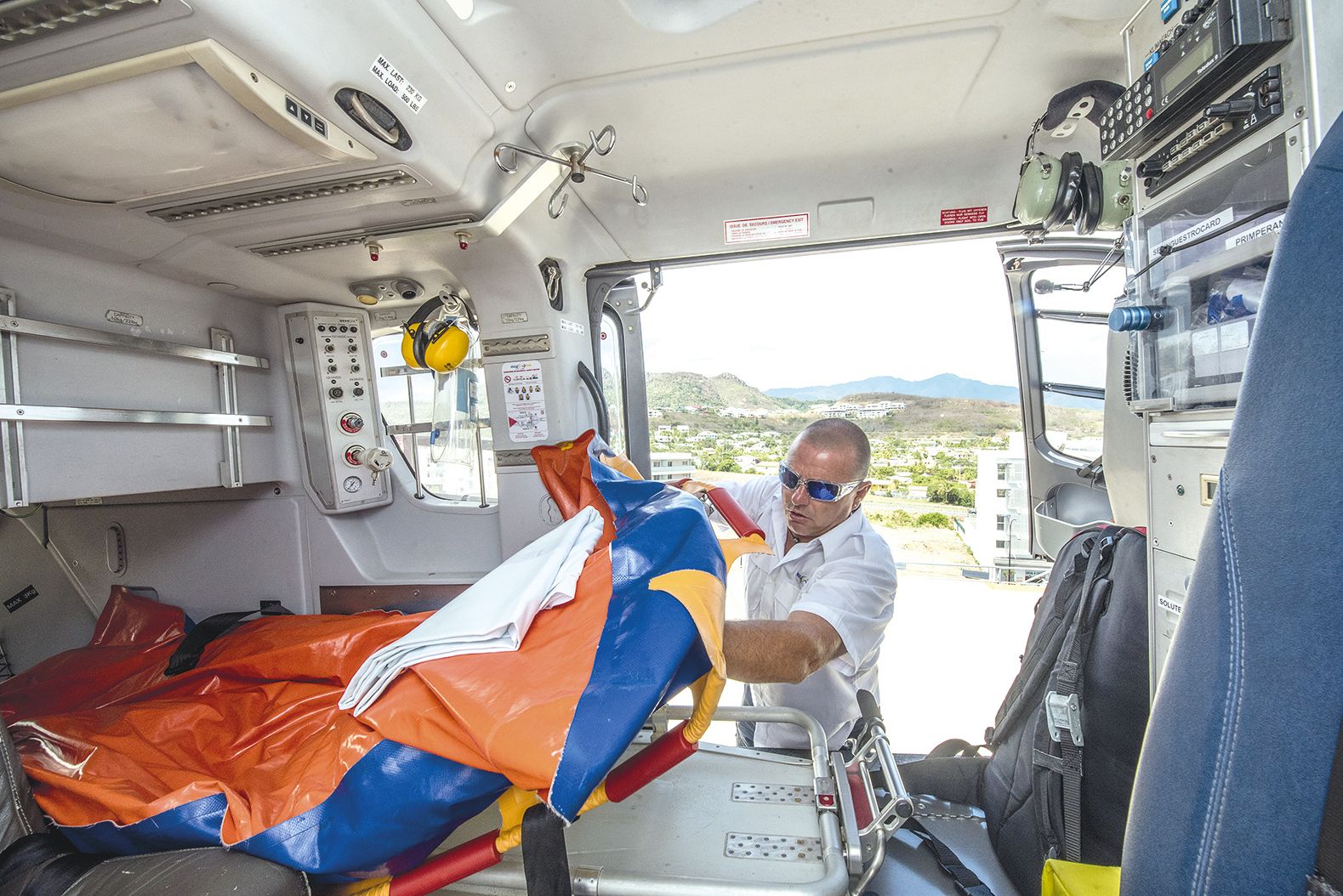 Florent, pilote expérimenté, montre la civière de l’hélicoptère, qui ne peut accueillir qu’un seul blessé. En opération, c’est systématiquement deux soignants qui sont embarqués : un médecin et un infirmier.