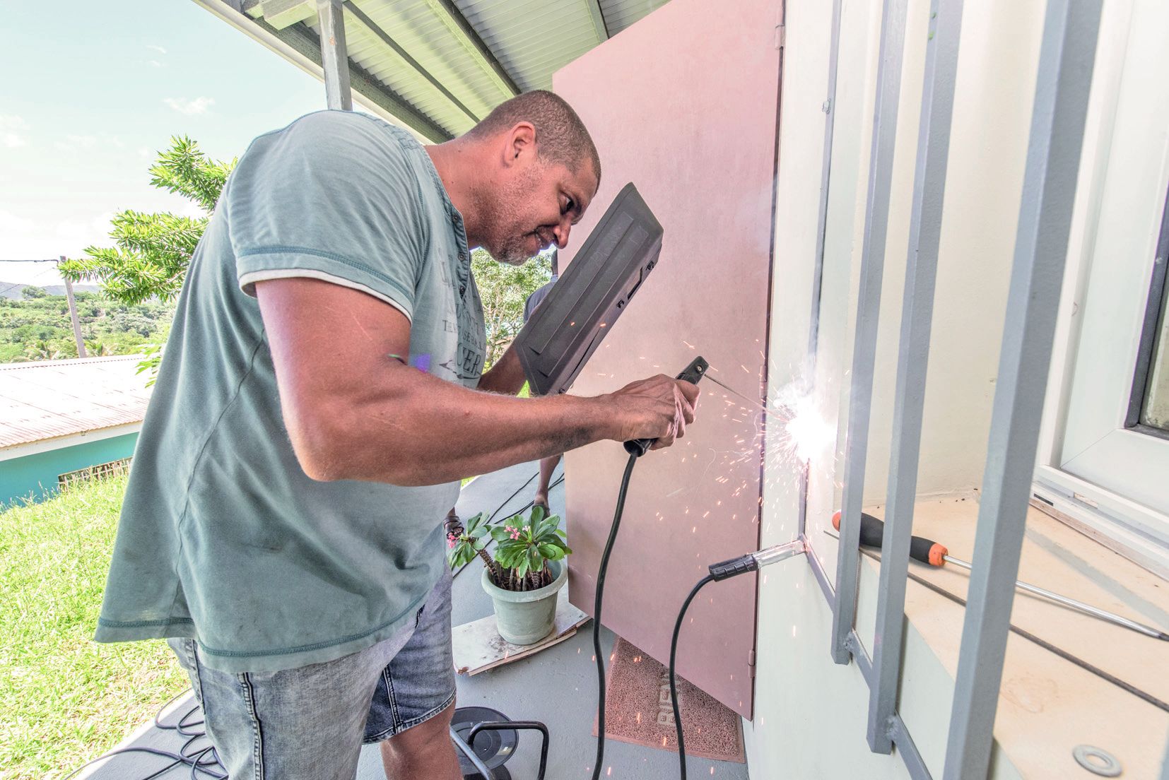 Jean-Michel soude les écrous des barreaux du bâtiment administratif de l’école primaire Ste-Thérèse après  le cambriolage.
