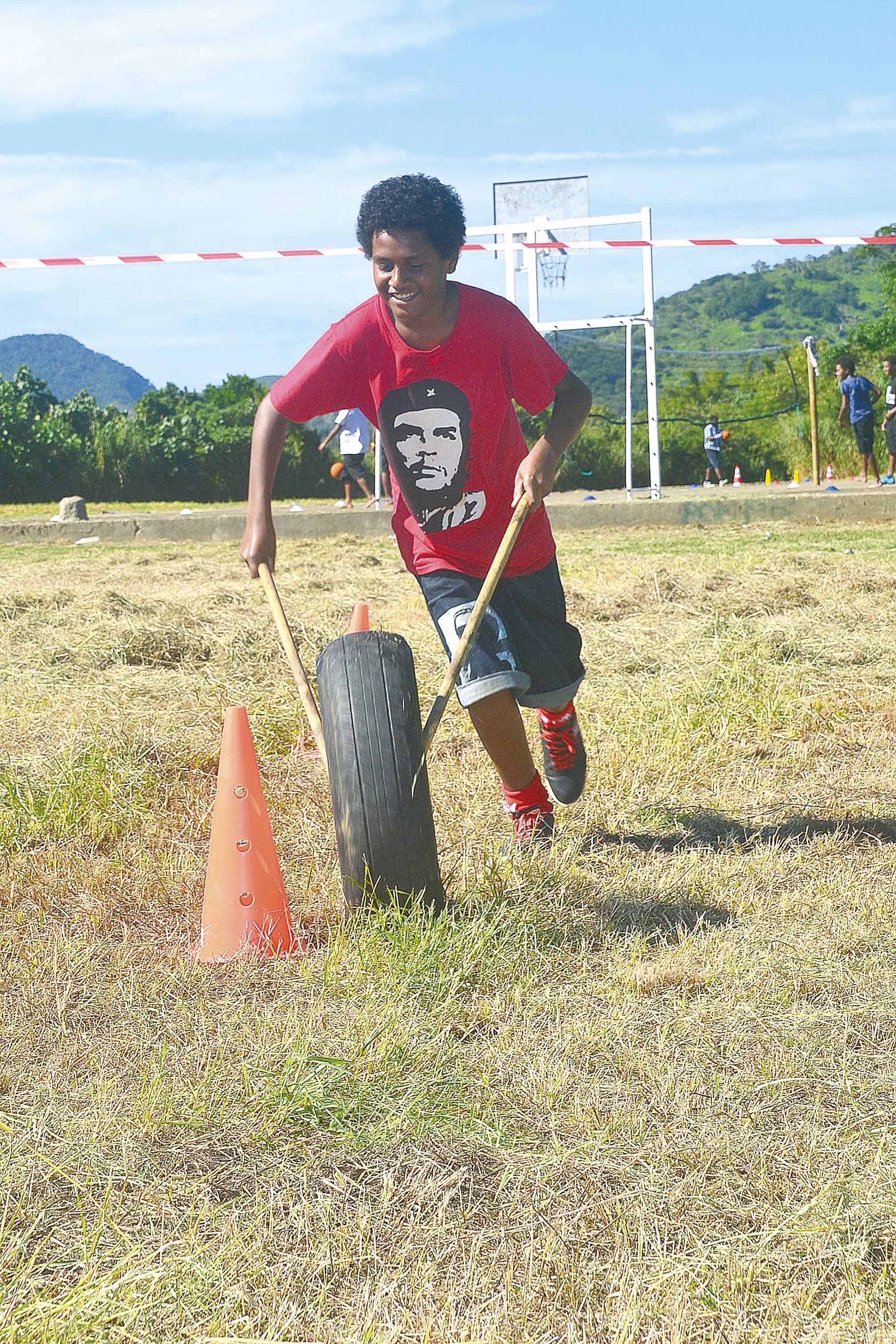 Railey, souriant mais concentré, sur le slalom de la roue. Comme «  ça freine trop »,  il a donc été décidé  de mettre de l’eau dans les roues pour faciliter le frottement.