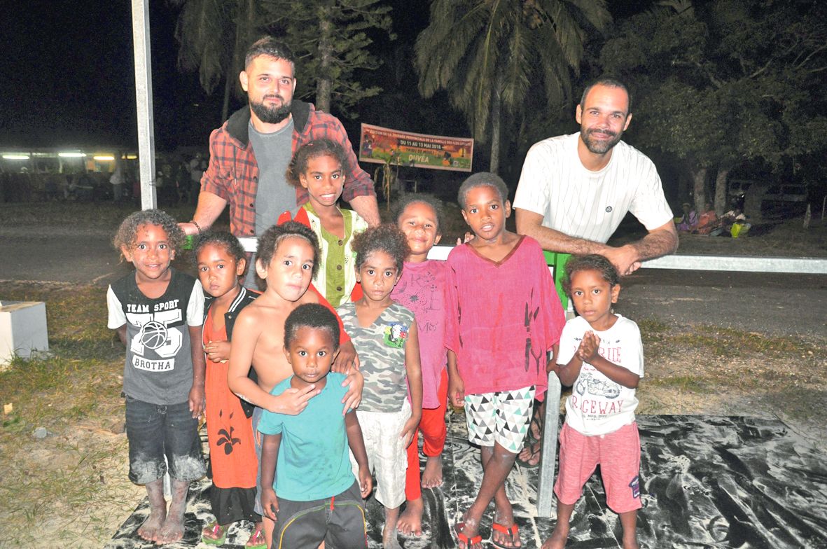 Hugo Lassauce (à gauche), de The Manta Trust, et Maël Imirizaldu de Conservation international NC entourent des enfants d’Iaaï à l’issue de l’avant-première dimanche à la tribu de Mouli.