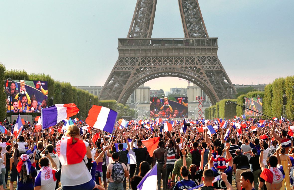Les supporters tricolores, rassemblés sur le Champ-de-Mars à Paris, exultent, lors de la remise de la Coupe du monde aux joueurs français.  