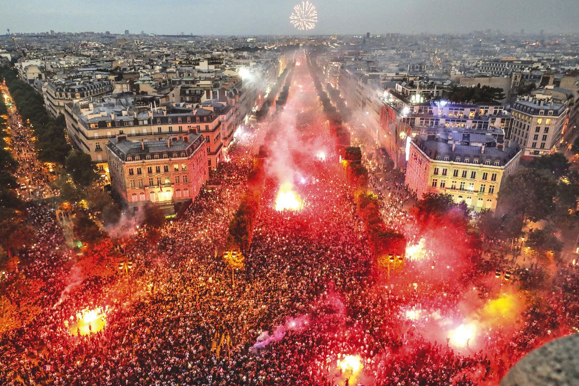 Paris est en liesse ! Une marée humaine déambule avec des fumigènes à la main, dans les rues de la capitale pour fêter la victoire de l’équipe de France, en finale de la Coupe du monde 2018. Des feux d’artifice ont également illuminé le ciel parisien. Cet