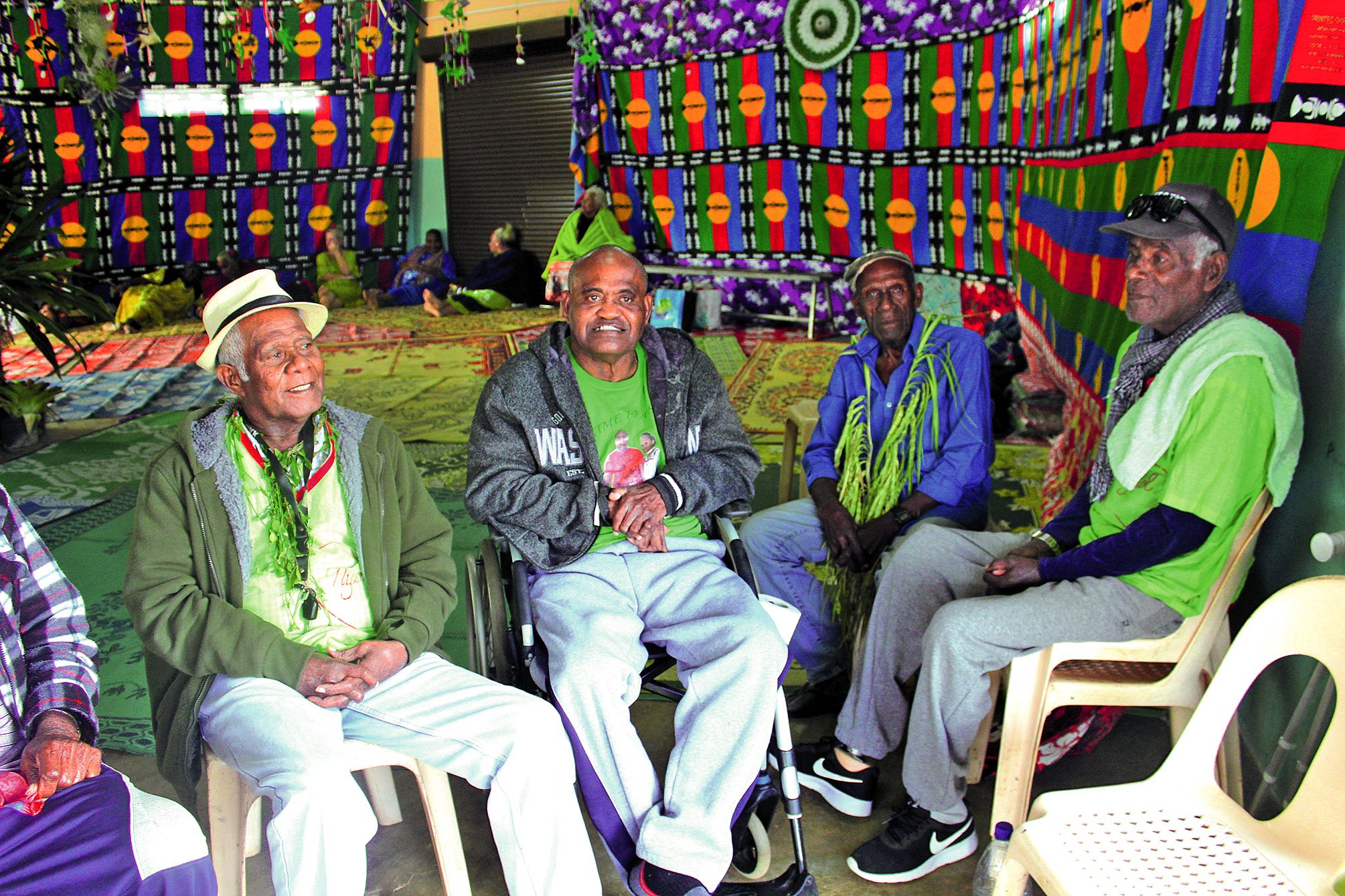 « Qenegei di » entouré par ses beaux-parents et un de ses sujets.