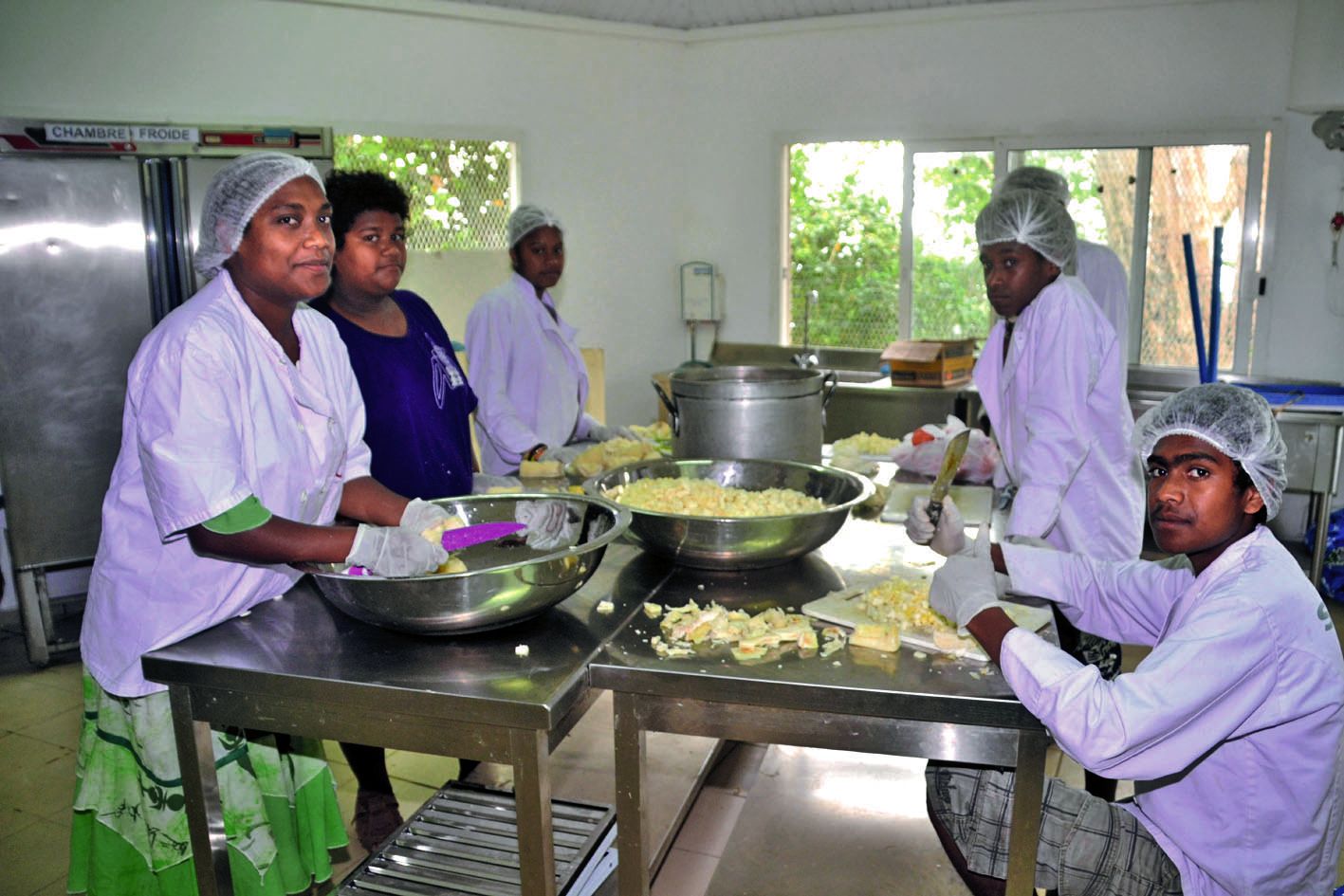 En cuisine, pour profiter pleinement des cultures, « on coupe du manioc, indique Richard (à droite), pour faire une salade ».  Elle sera préparée au lait de coco, comme une salade de poisson.