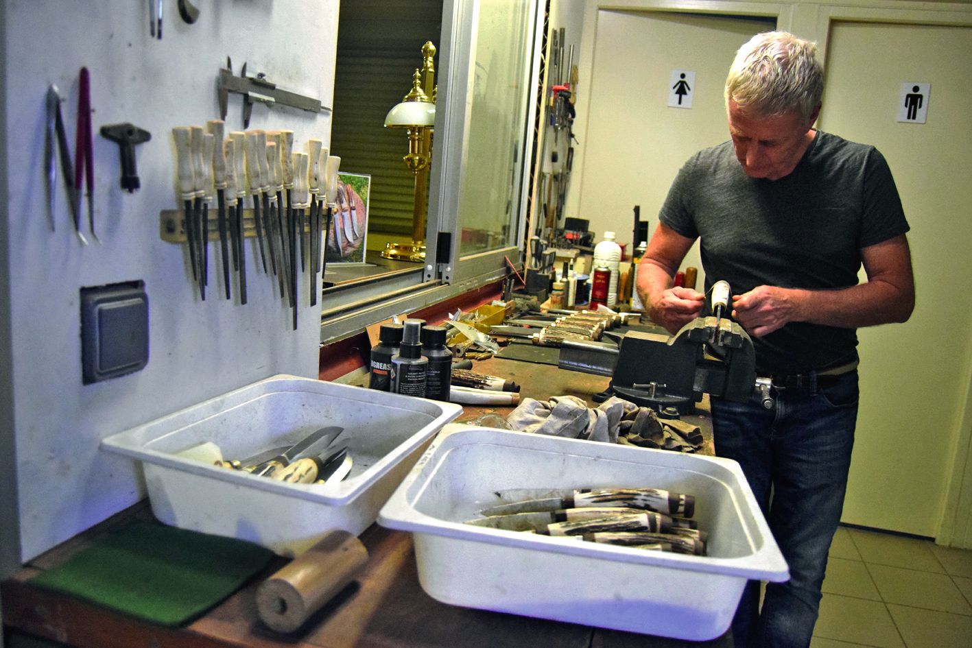 Dans son atelier, intégré à même la boutique, André Ouin crée  des couteaux et répare des armes.