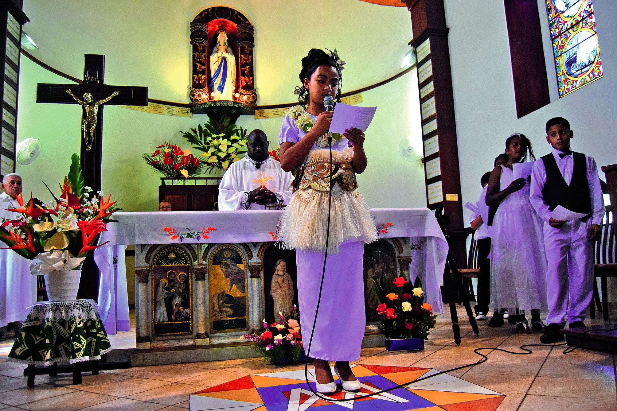 Tess lit une prière Universelle. Un moment impressionnant pour la petite fille qui se retrouve face à la foule de fidèles.