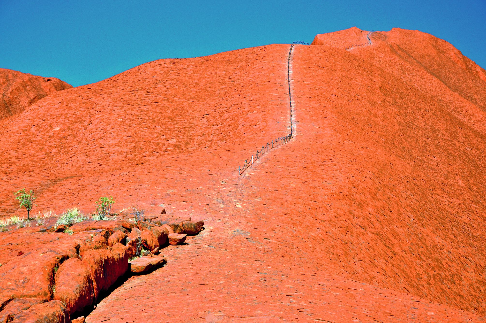 Au pied du massif, un large panneau recommande de ne pas escalader Uluru par respect pour les propriétaires aborigènes.La chaîne qui aide les touristes à monter et à descendre, aurait été coupée, lors du 30e anniversaire de la rétrocession, en octobre 201