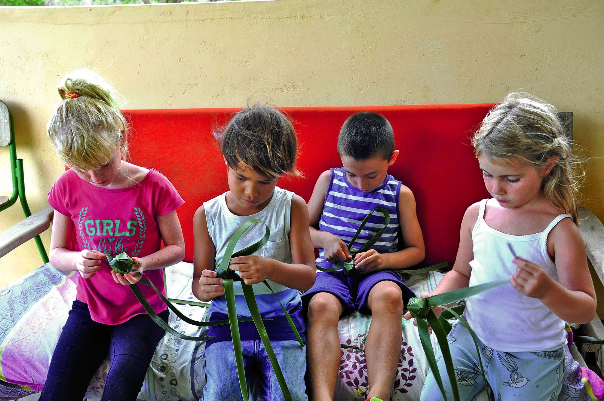 Irma, animatrice,  a initié les enfants au tressage de feuilles de cocotier afin de réaliser de petites balles.