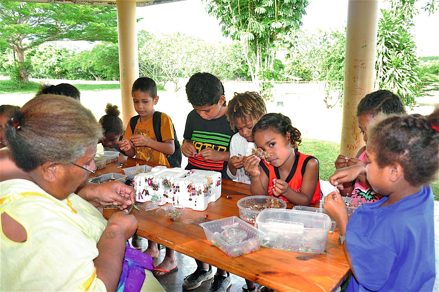 Le groupe des petits a écouté les conseils de Monique,  une maman  de l’association, pour réaliser des bijoux  à l’aide de perles et de graines locales.