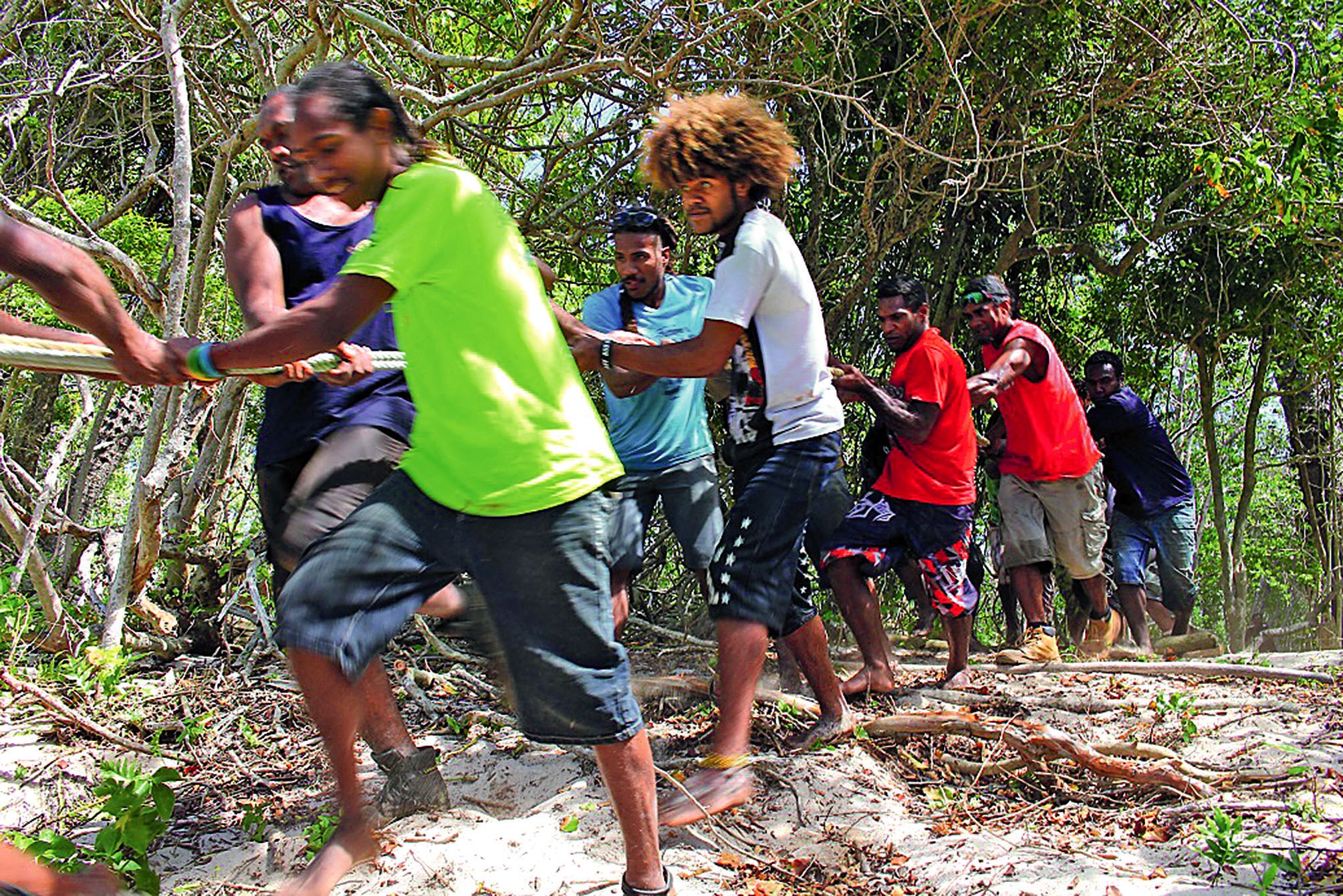 Tous les jeunes de la famille Vakume sont réunis pour tracter l’embarcation sur le chemin de rondins de bois préparé en amont.