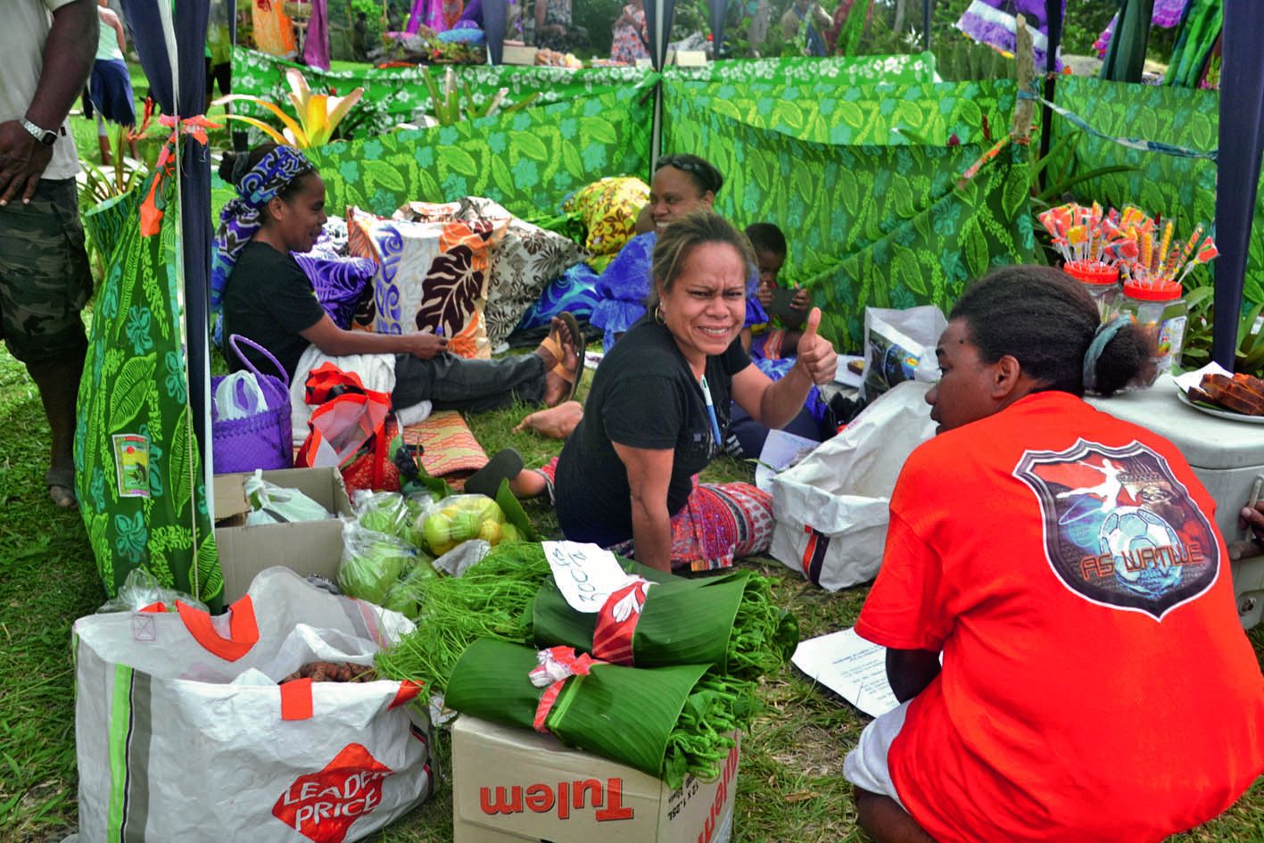 Gina, Evelyne et Rébecca (assises) sont venues proposer  des oranges, des pommes-lianes, des piments... et quelques articles de vannerie.