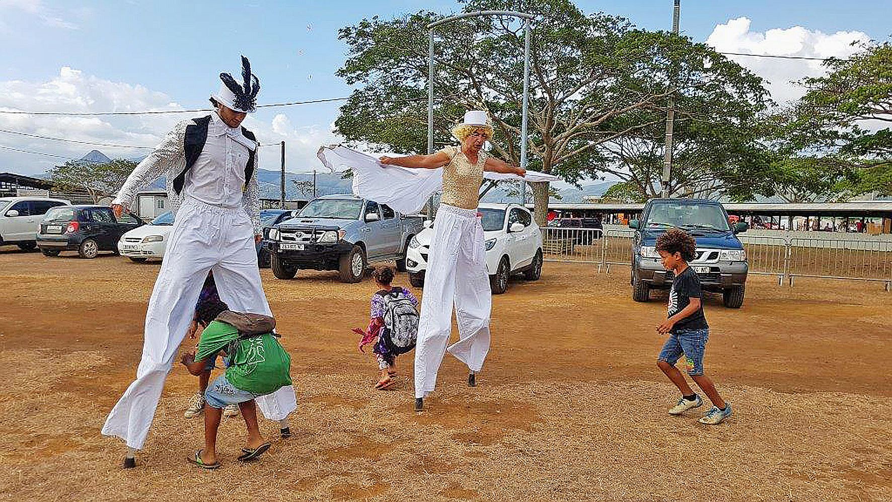 Des échassiers erraient à travers le champ de foire, alpagués par les parents qui voulaient prendre des photos.