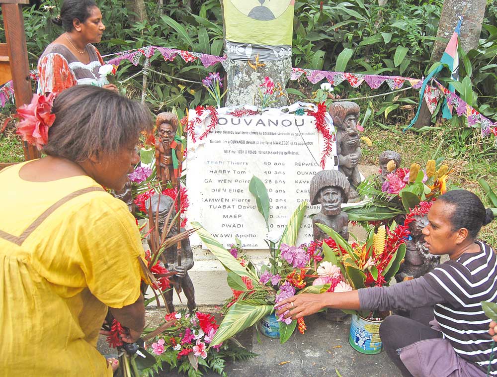 Au premier plan, Imelda Pada (à gauche) et Audray Teouvet, membres du comité  organisateur, fleurissent la stèle commémorative.