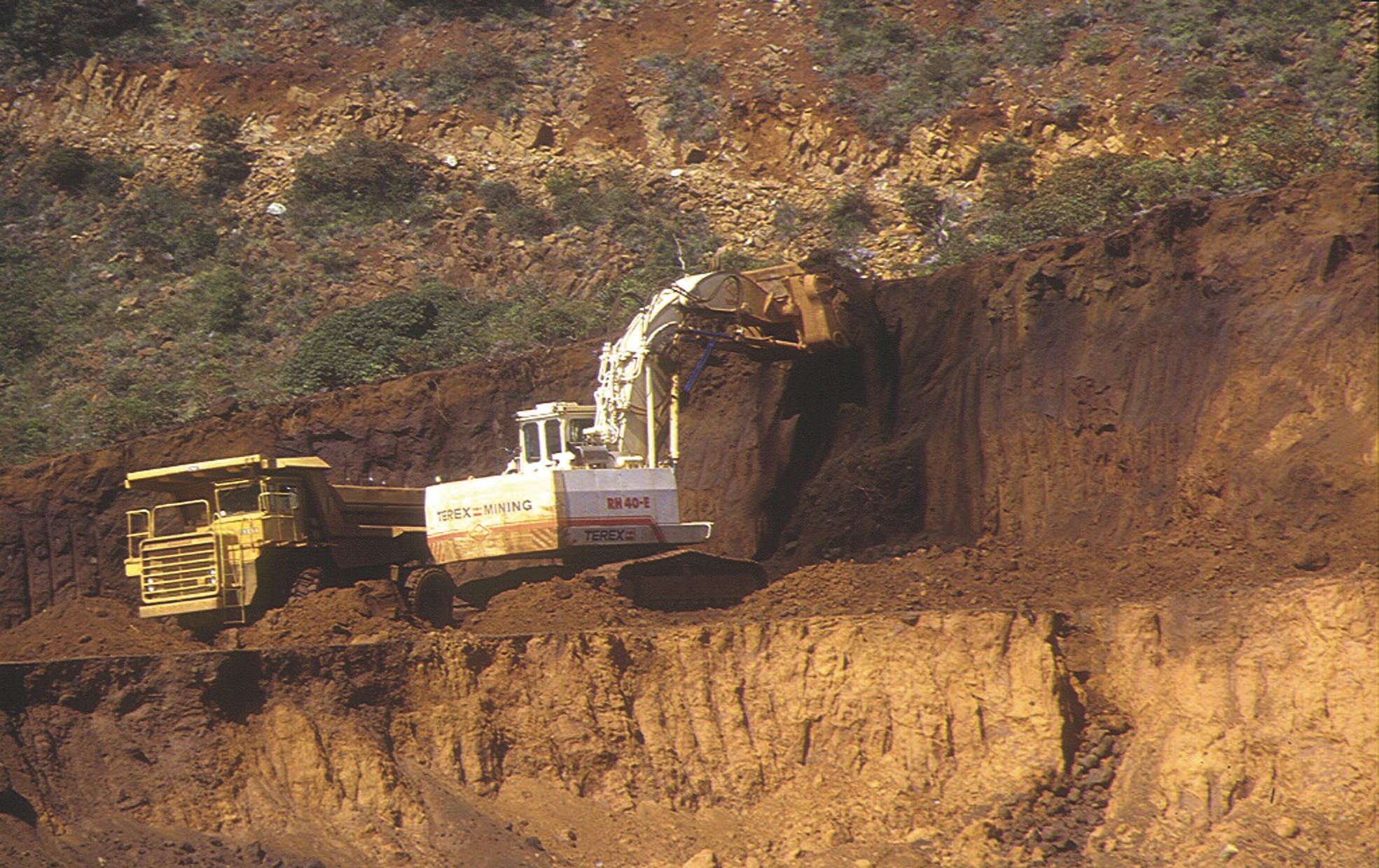 Une pelle hydraulique et un dumper au décapage, deuxième étape de l'exploitation.