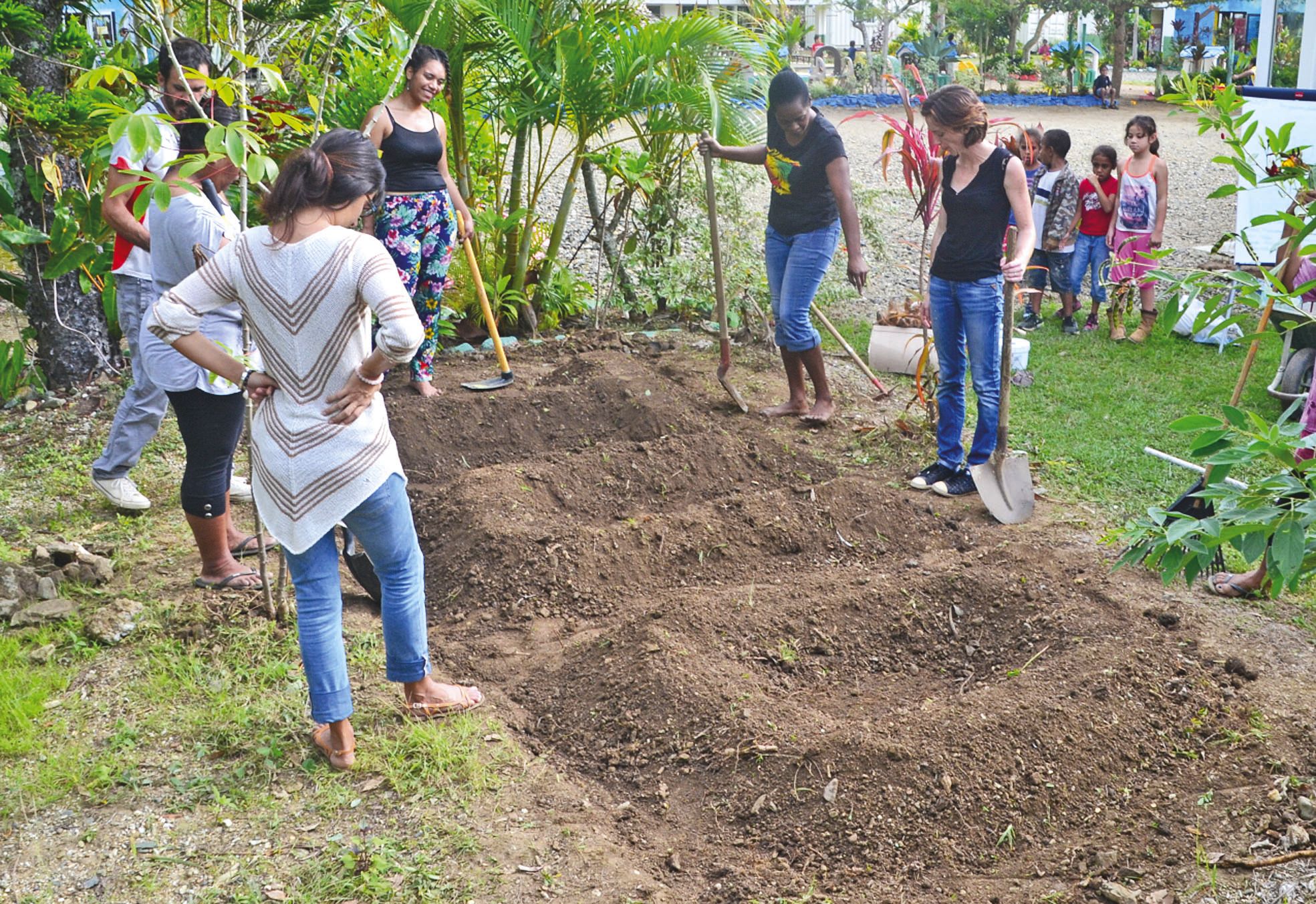 École Marie-Emerante, vendredi 24 juin. Les stagiaires n'ont pas hésité à user de l'huile de coude. Quand légumes et fleurs pousseront, les lettres TUO fleuriront dans l'école.
