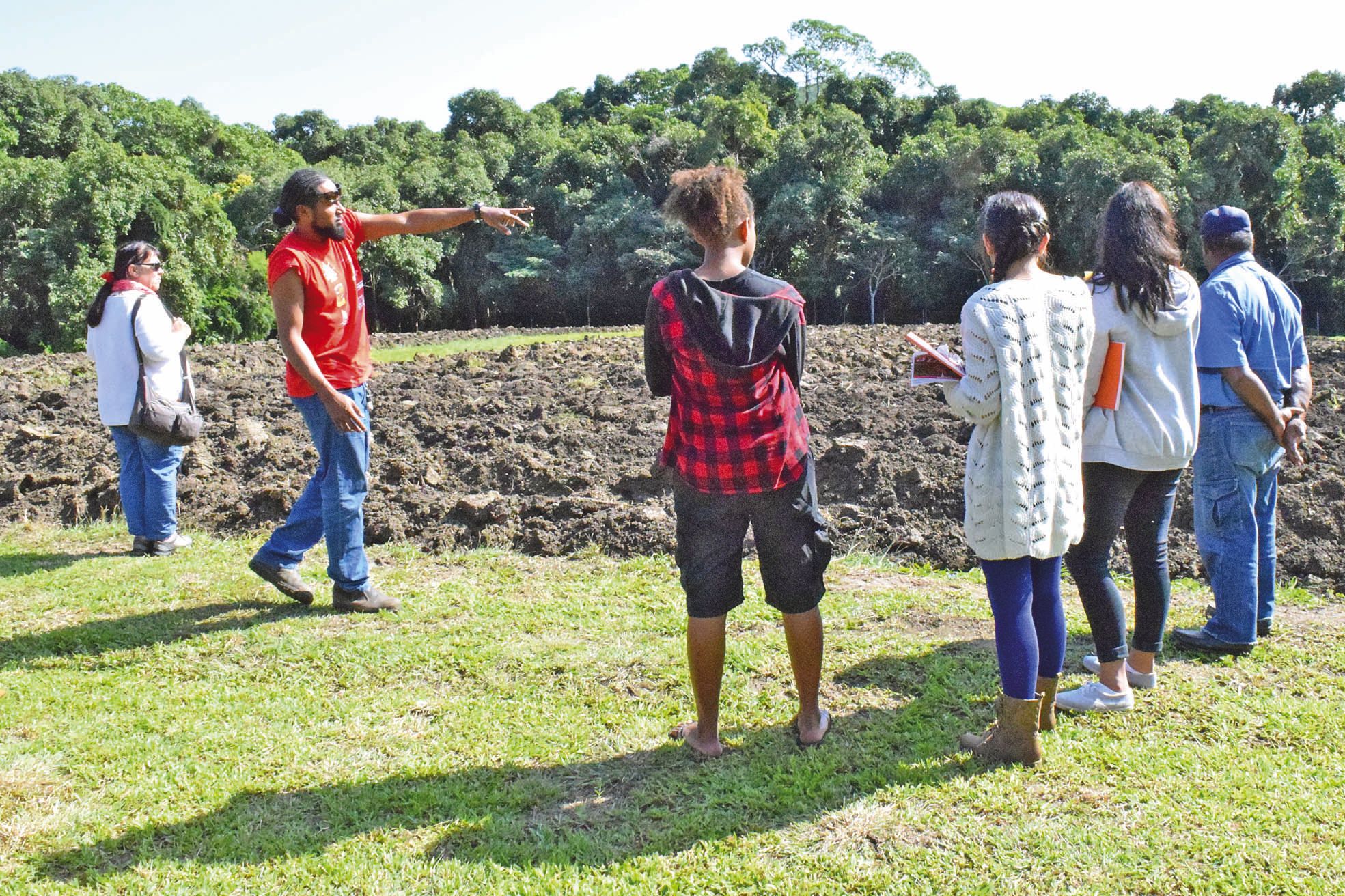 Conservatoire de l'igname, mercredi 6 juillet. Stacey Selefen (en rouge) montre aux élèves du lycée Anova les parcelles dévolues à la multiplication des variétés du tubercule roi. 