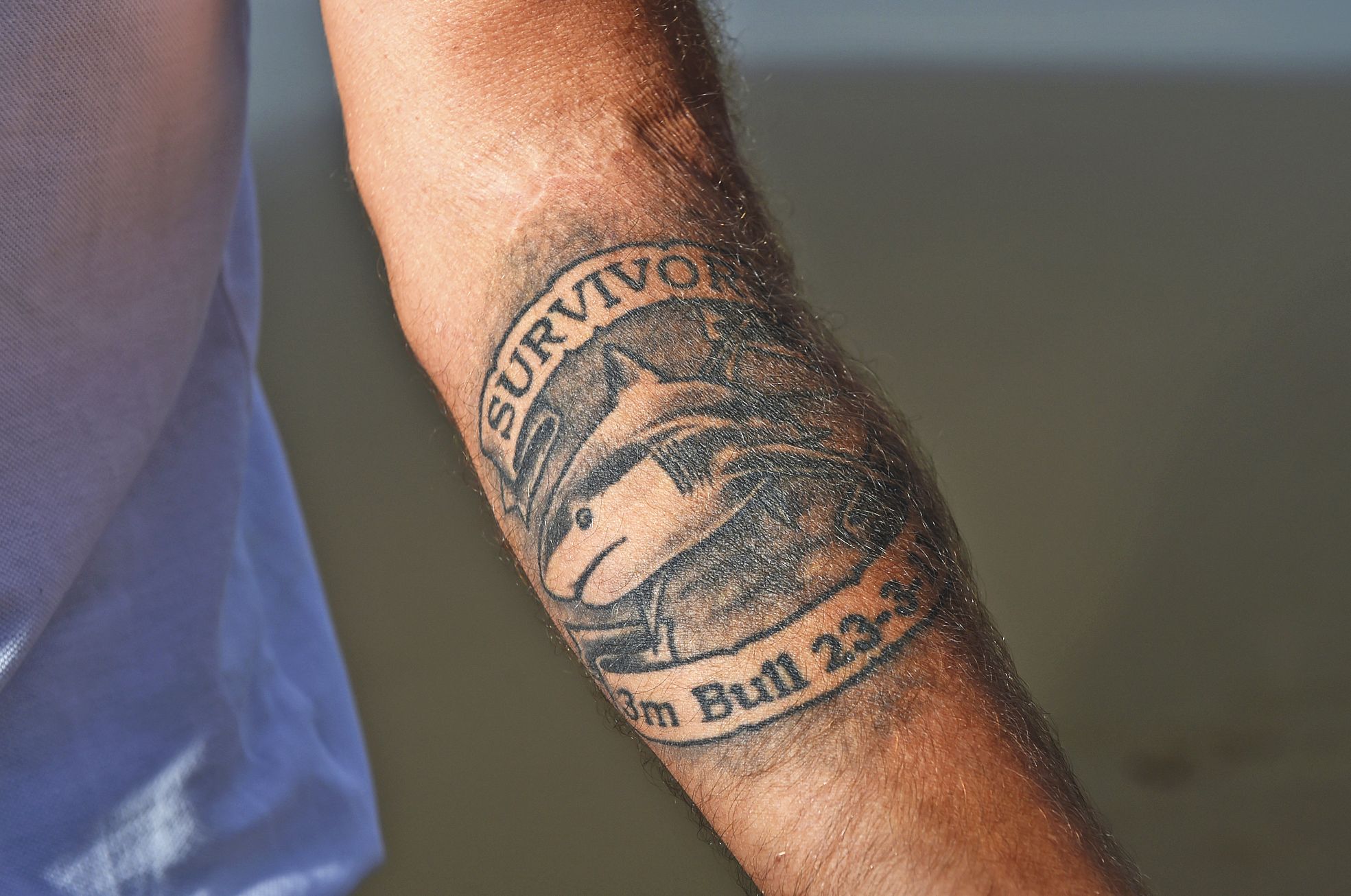 Ballina, le 1er mai. Dave Pearson, victime d'une attaque de requin-bouledogue en 2011,  au sud de Ballina, arbore un tatouage « survivant », avec la date de l'attaque.