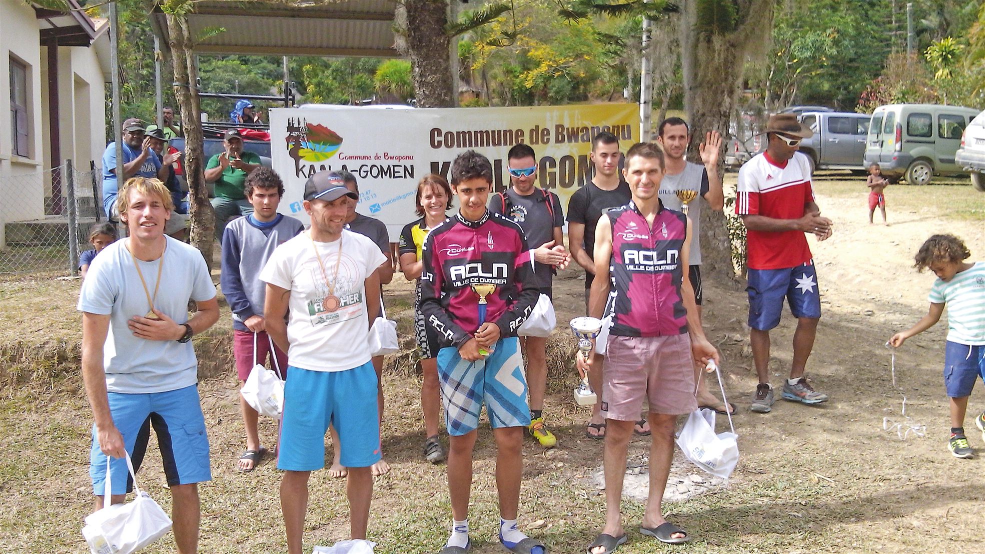 Les concurrents ont été récompensés devant la maison commune de la tribu de Wemou. Parmi la cinquantaine de concurrents figurait un seul jeune de Kaala-Gomen, Jayen Macq. De gauche à droite (podium scratch) : Florian Boyer-Resser (3e), Cédrick Oblet (4e),