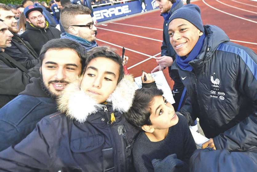 Les Bleus, à l’image de Kylian Mbappé (à droite), ont eu droit à un petit bain de foule hier après l’entraînement.