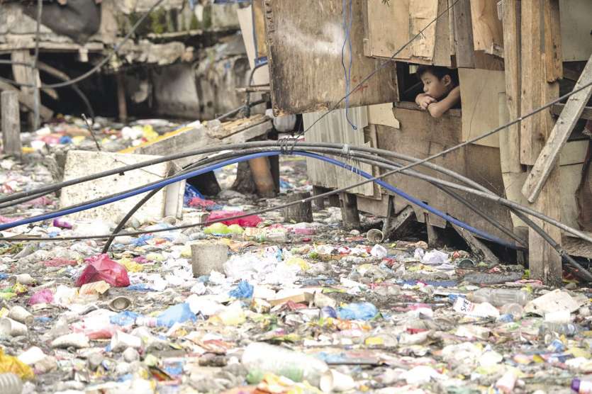 Un bouclier de détritus cache l’Estero de Magdalena, un cours d’eau qui serpente dans un bidonville de Manille, aux Philippines. La couche est si épaisse qu’on croirait pouvoir marcher dessus.Photo AFP
