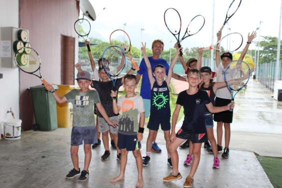 Raquettes et balles jaunes en main, durant l'été, au tennis club