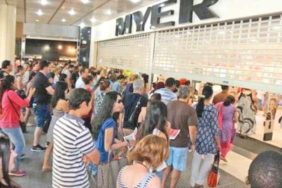 Des gens campent devant les magasins