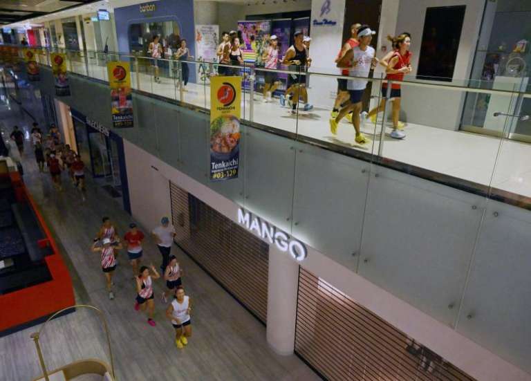 À Singapour, des joggeurs courent dans un centre commercial pour échapper aux fumées des incendies indonésiens